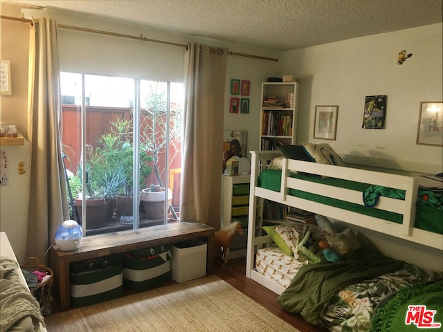 bedroom with light hardwood / wood-style floors and a textured ceiling