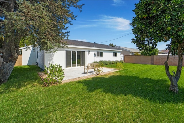 rear view of property with a patio area and a yard