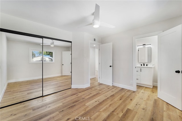 unfurnished bedroom with a closet, ceiling fan, connected bathroom, and light hardwood / wood-style flooring