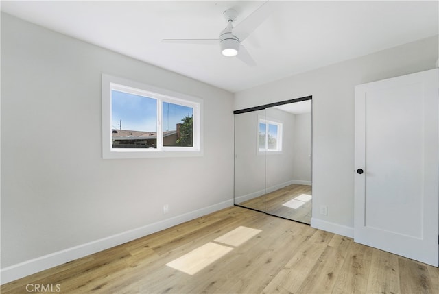 unfurnished bedroom with a closet, light wood-type flooring, and ceiling fan