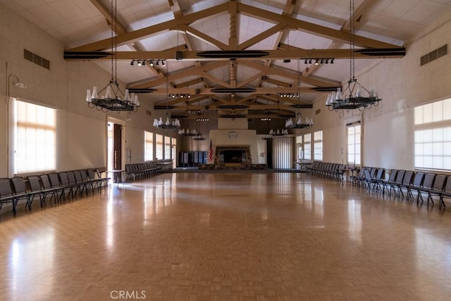 interior space with high vaulted ceiling, visible vents, a chandelier, and beamed ceiling