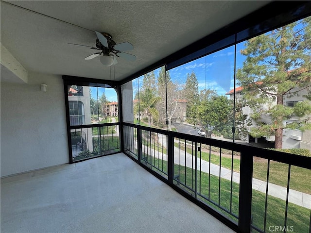 unfurnished sunroom featuring a ceiling fan