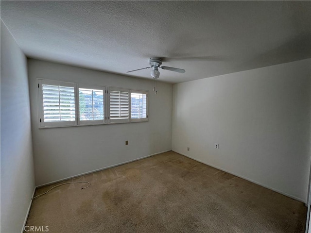 empty room featuring light carpet, ceiling fan, and a textured ceiling