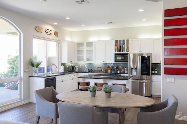 kitchen with hardwood / wood-style floors, white cabinetry, and black appliances