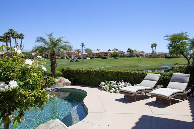 view of pool featuring a yard, a water view, and a patio