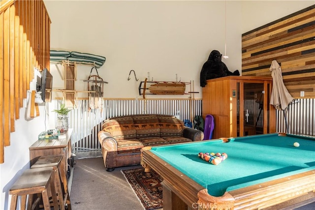 playroom featuring wood walls, dark colored carpet, a high ceiling, and pool table