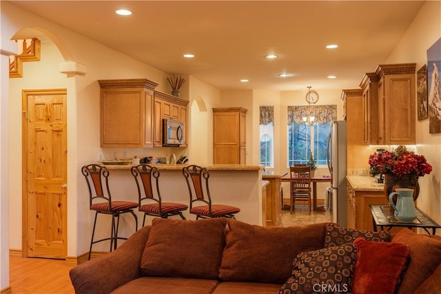 living room featuring light hardwood / wood-style flooring and a notable chandelier