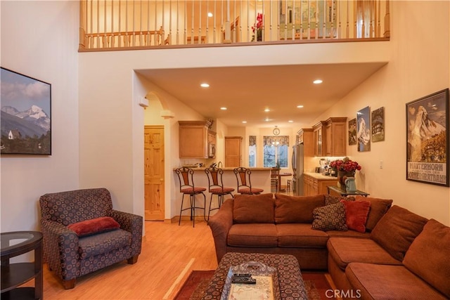 living room featuring a high ceiling and light wood-type flooring