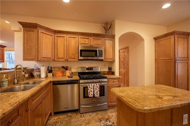 kitchen with light stone counters, sink, and stainless steel appliances