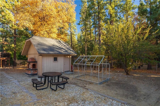 view of patio / terrace featuring an outbuilding and an outdoor fireplace