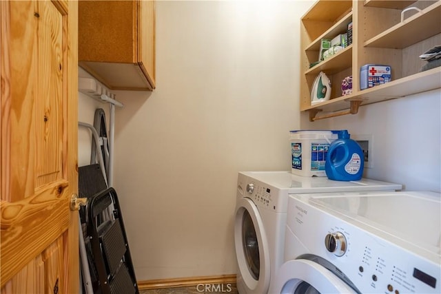 clothes washing area featuring cabinets and washing machine and dryer