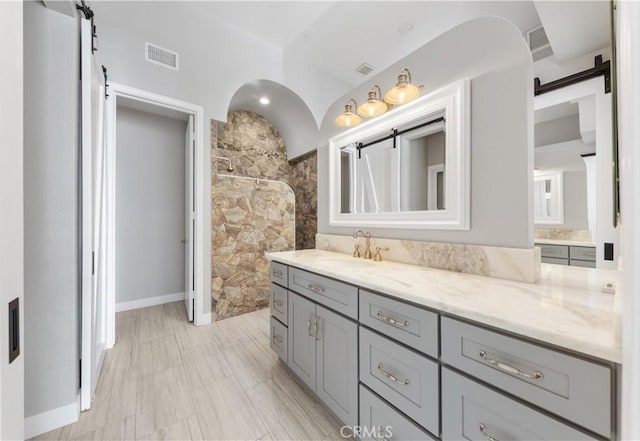 bathroom featuring vanity, walk in shower, and tile walls