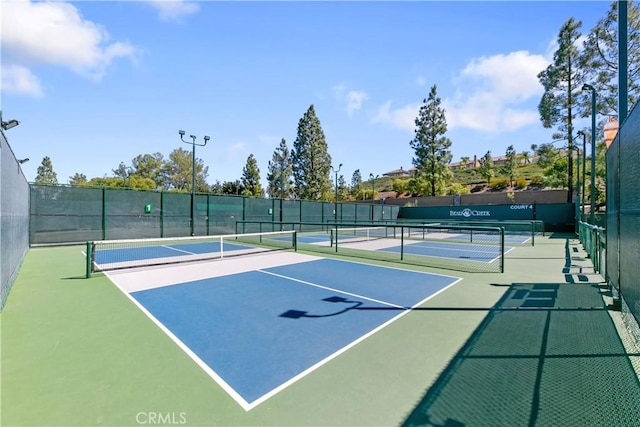 view of tennis court featuring basketball hoop