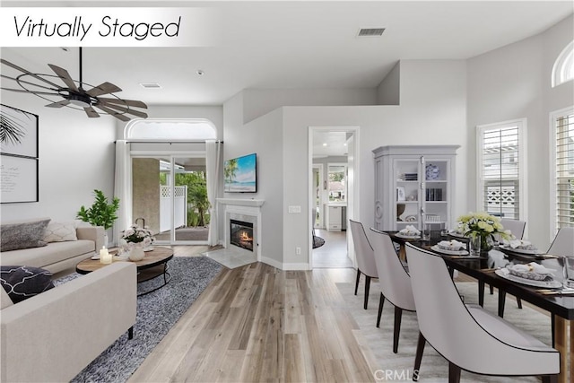 living room with ceiling fan, light hardwood / wood-style floors, and a high end fireplace