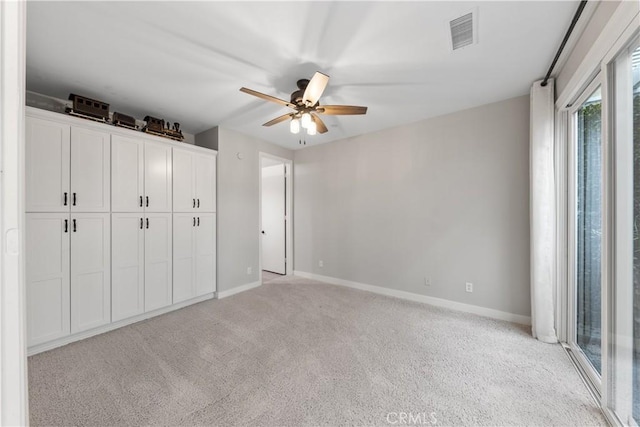 unfurnished bedroom featuring access to exterior, a closet, light colored carpet, and ceiling fan