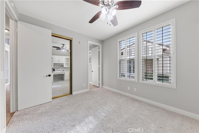 unfurnished bedroom featuring ceiling fan, a closet, and light carpet