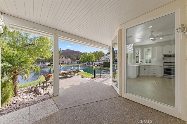 view of patio featuring area for grilling, a water and mountain view, and sink