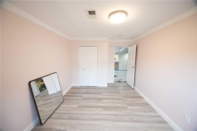 hall featuring crown molding and light hardwood / wood-style flooring