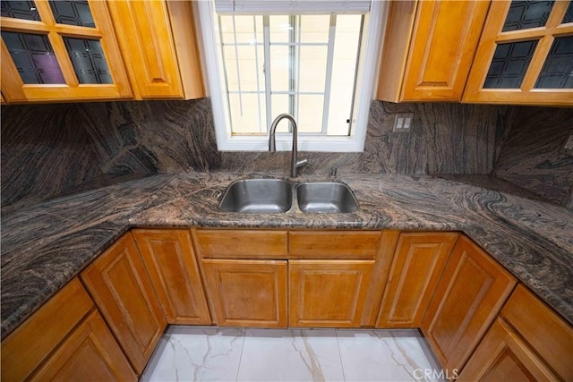 kitchen with decorative backsplash, dark stone counters, and sink