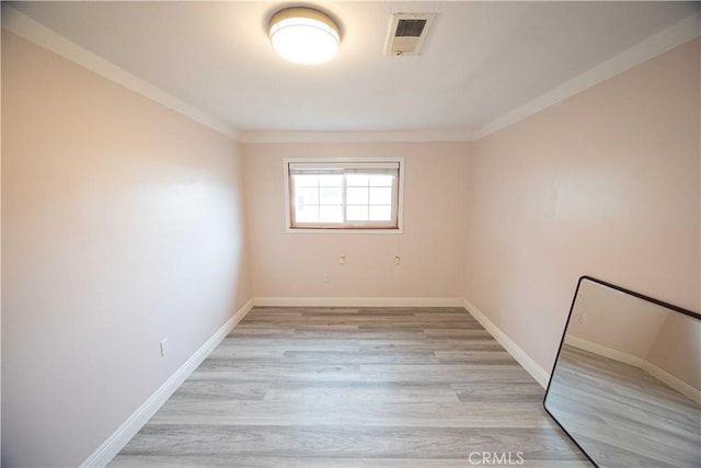 unfurnished room featuring light hardwood / wood-style floors and ornamental molding