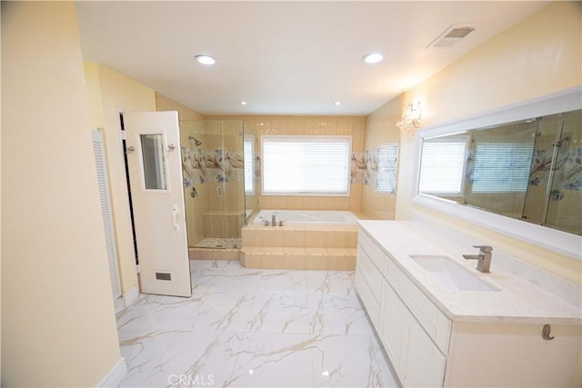 bathroom with vanity and shower with separate bathtub