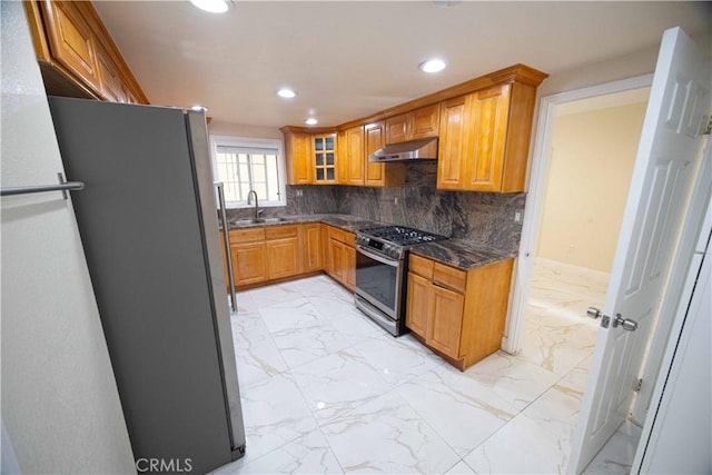 kitchen featuring backsplash, dark stone countertops, sink, and appliances with stainless steel finishes