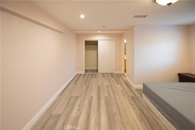 bedroom with a closet and light hardwood / wood-style flooring