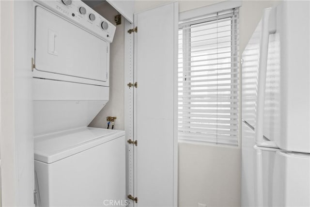 laundry room with stacked washing maching and dryer