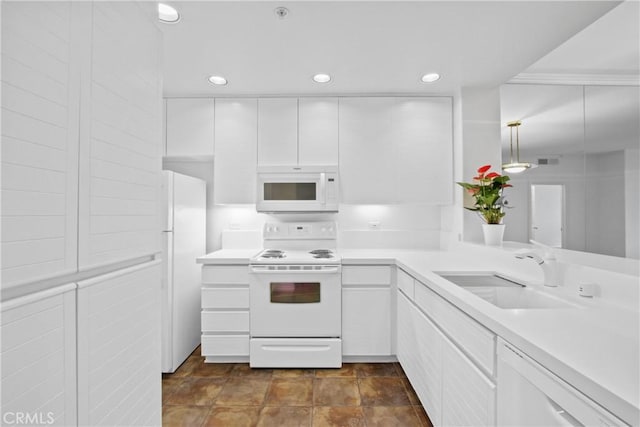 kitchen featuring sink, white cabinets, hanging light fixtures, and white appliances