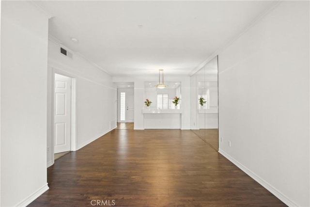 unfurnished living room featuring dark hardwood / wood-style floors and ornamental molding