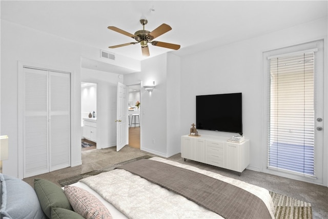 bedroom with ceiling fan, light colored carpet, connected bathroom, and a closet