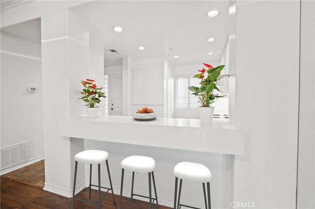 kitchen featuring a kitchen bar and dark hardwood / wood-style flooring