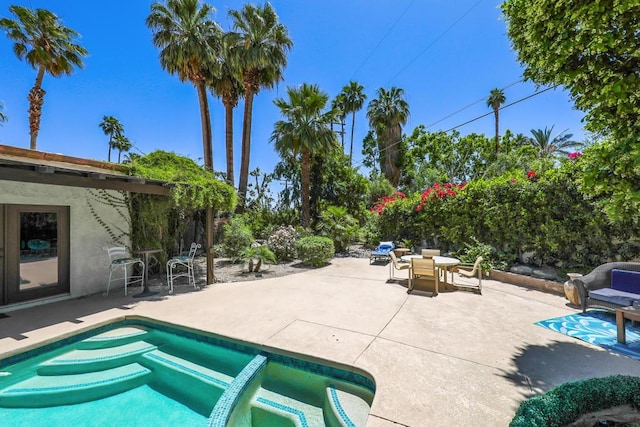 view of pool with a jacuzzi and a patio