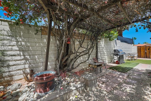 exterior space with area for grilling and a pergola