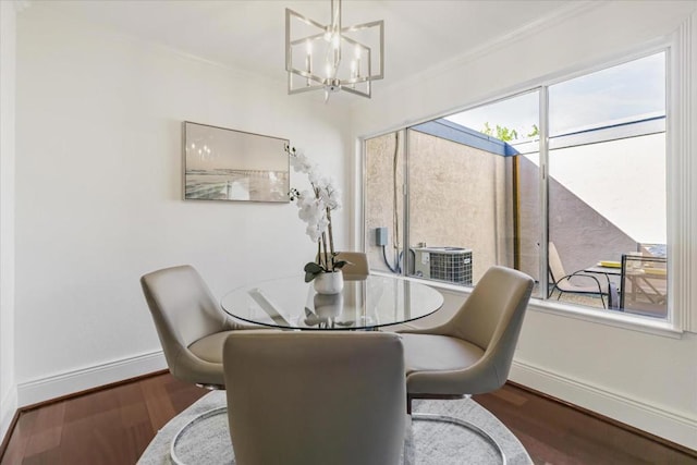 dining area with dark hardwood / wood-style flooring, a wealth of natural light, and ornamental molding