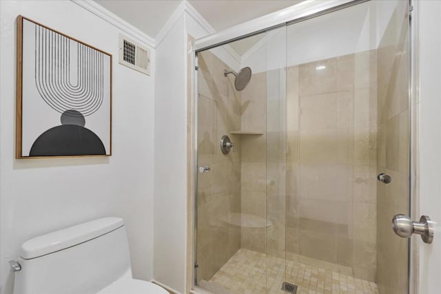 bathroom featuring ornamental molding, toilet, and a shower with shower door