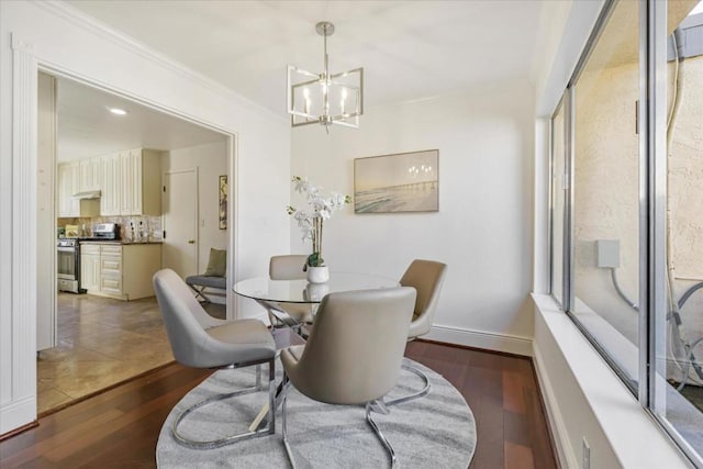 dining room with a healthy amount of sunlight, dark wood-type flooring, and ornamental molding