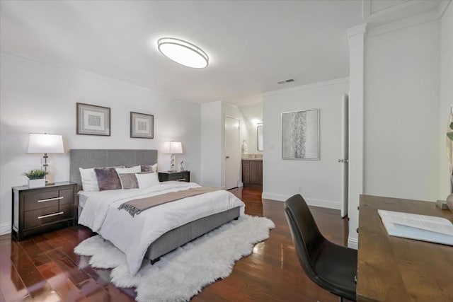 bedroom featuring ensuite bathroom, crown molding, and dark wood-type flooring