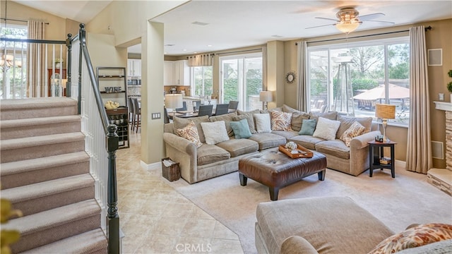 carpeted living room with vaulted ceiling, ceiling fan, and plenty of natural light