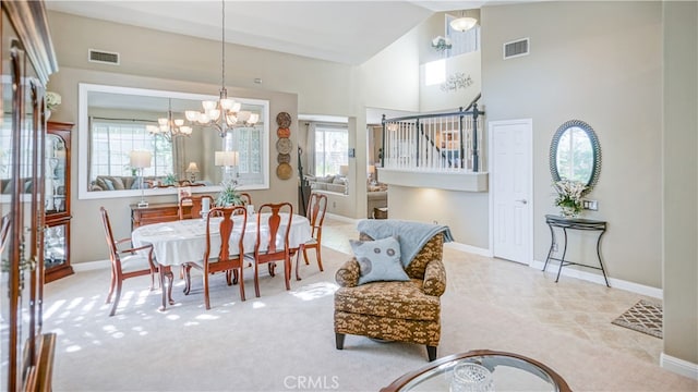 carpeted dining room with a chandelier and high vaulted ceiling