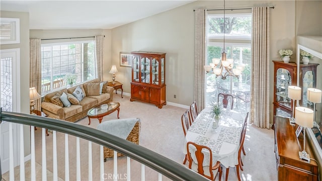 living room with a wealth of natural light, vaulted ceiling, and an inviting chandelier