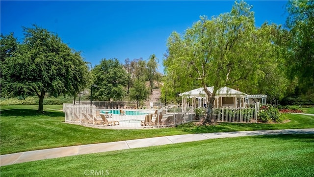 surrounding community with a patio, a yard, and a swimming pool