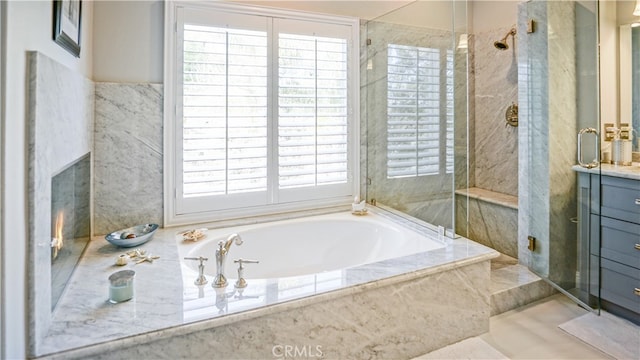 bathroom featuring vanity, a healthy amount of sunlight, and separate shower and tub