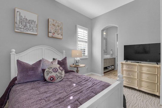 bedroom featuring light hardwood / wood-style floors and connected bathroom