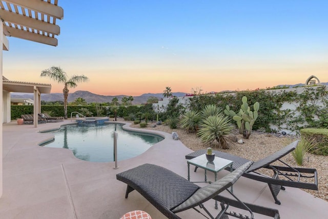 pool at dusk featuring a mountain view, a patio, a pergola, and an in ground hot tub