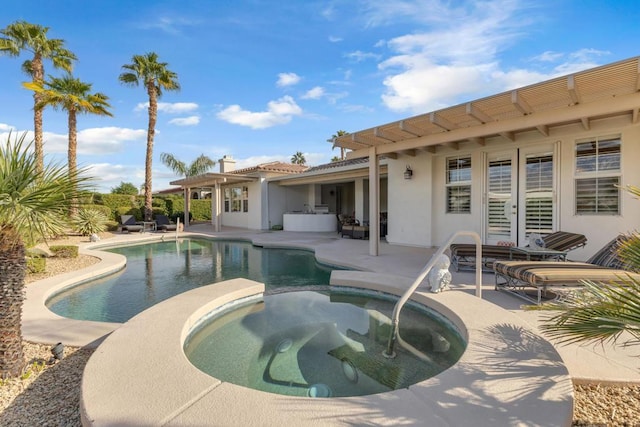 view of pool with a patio area and an in ground hot tub