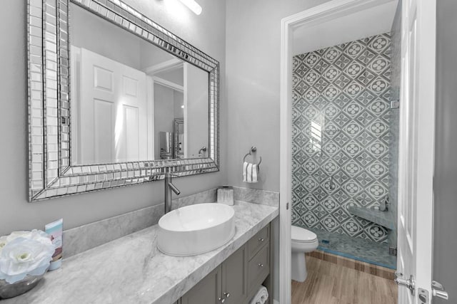 bathroom featuring vanity, hardwood / wood-style flooring, toilet, and walk in shower