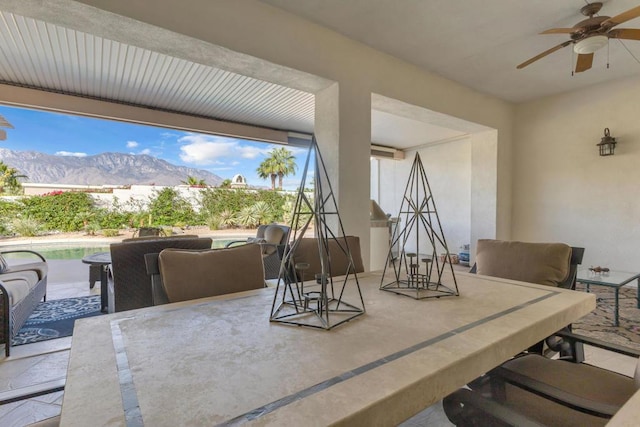 view of patio with exterior bar, a mountain view, and ceiling fan