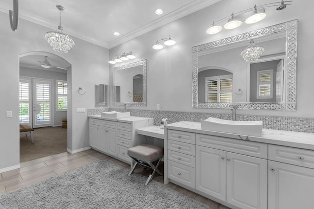 bathroom with ceiling fan, ornamental molding, decorative backsplash, vanity, and hardwood / wood-style flooring