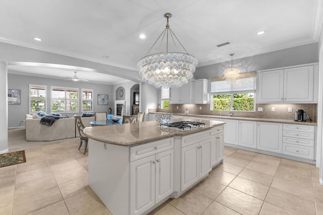 kitchen with ceiling fan with notable chandelier, a center island, and white cabinetry